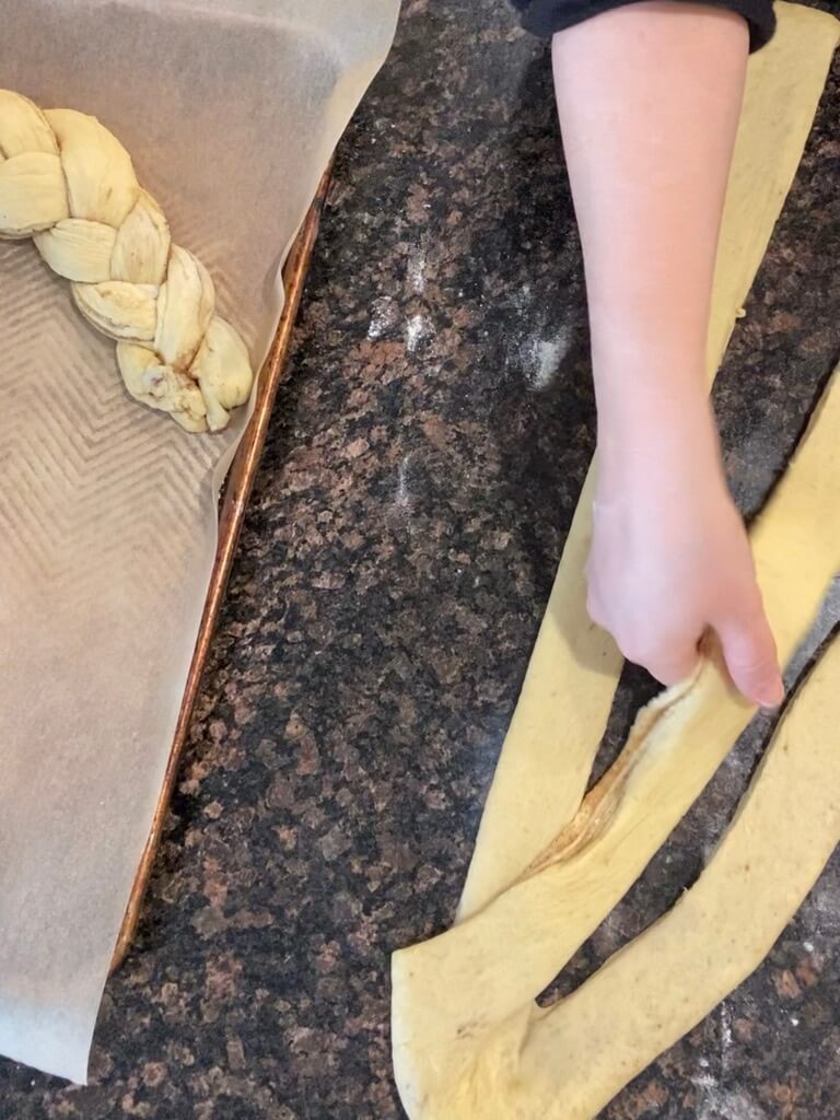 folding one strip of dough over center strip of dough