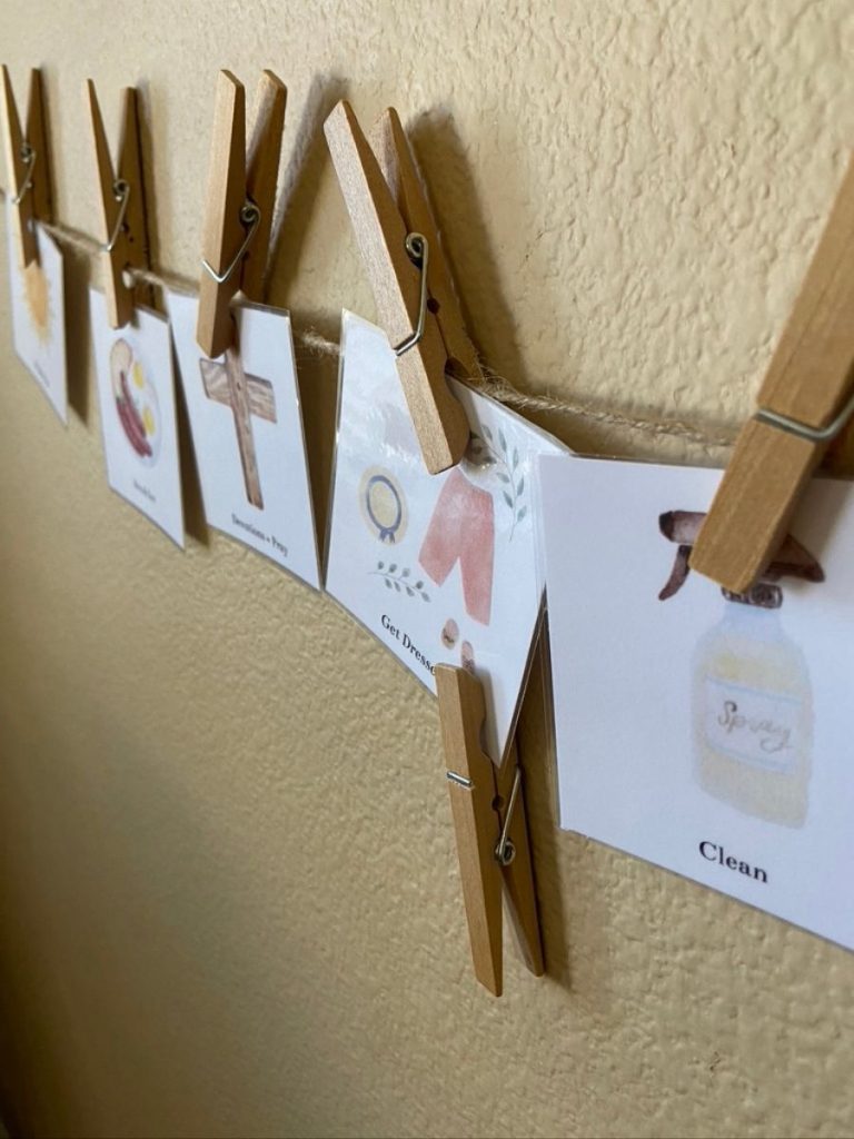 daily routine schedule printables hanging on wall with clothespins marking the current activity