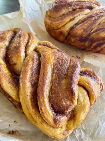 This Pumpkin Sourdough Babka Recipe is a fun twist on the traditional chocolate filled babka. The sourdough babka is light and fluffy, with a delicious swirl of sweet pumpkin filling. This recipe will break the process down into easy steps, and the result will be an impressively beautiful dessert bread!