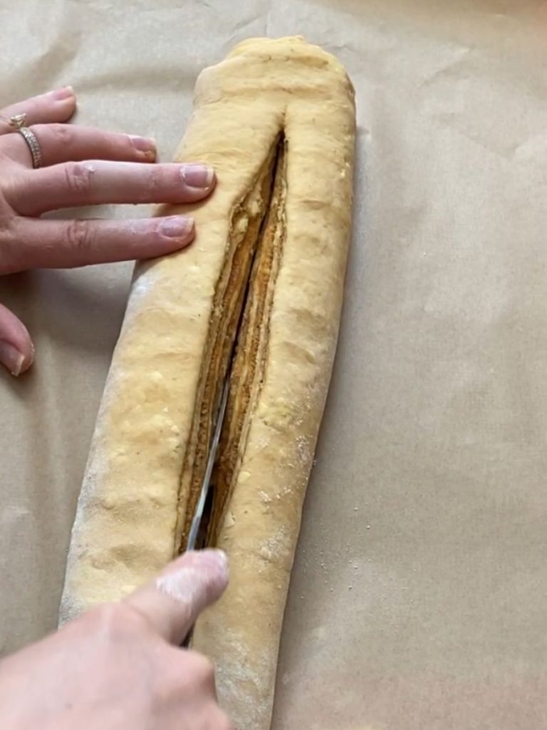 slicing log of dough with knife