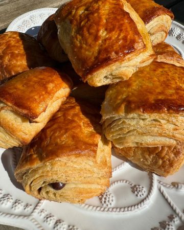 Made with layers of flakey buttery dough, these Sourdough Chocolate Croissants (Pain au Chocolat) are simply exquisite and so delicious. These croissants are crispy and light on the outside while the inside melts in your mouth with delicious chocolate sweetness throughout.
